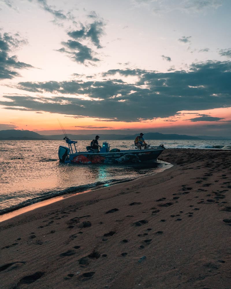 Sunset and boat on deserted beach