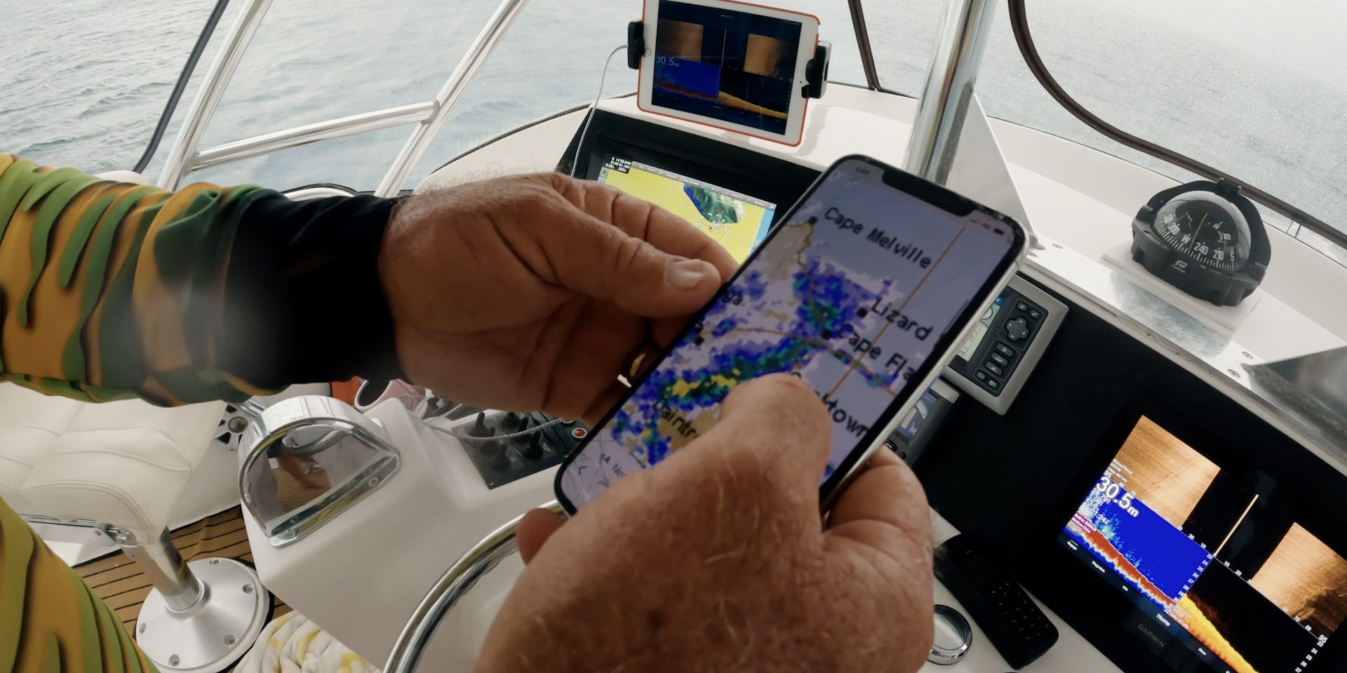 Boat skipper looking at weather app in boat